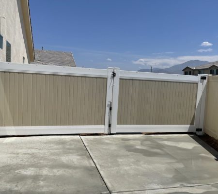 A white gate stands open in front of a house, inviting entry into the property.