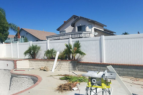 A pool fence is being constructed in front of a house, ensuring safety and security for the outdoor area.